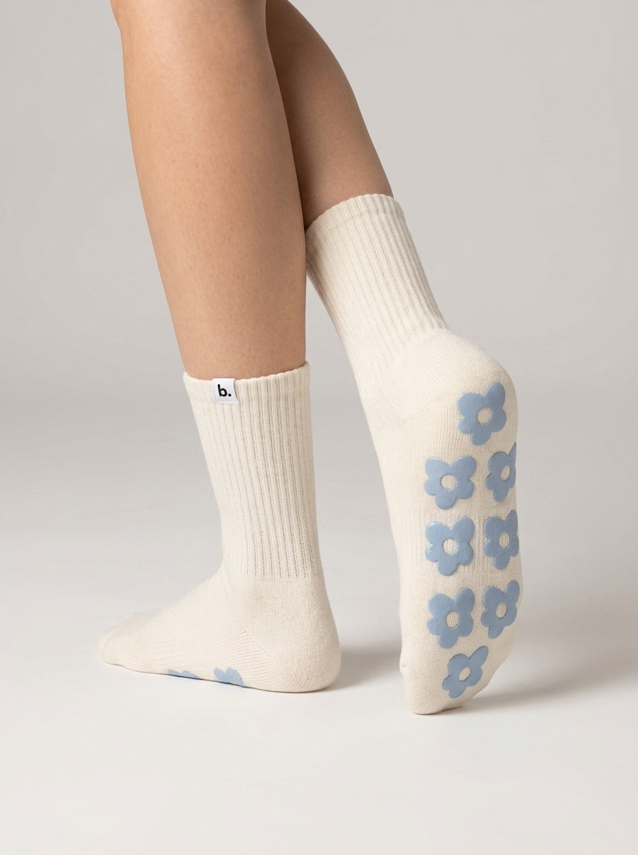 Cream pilates grip socks with sky-blue silicone flower grips on the sole