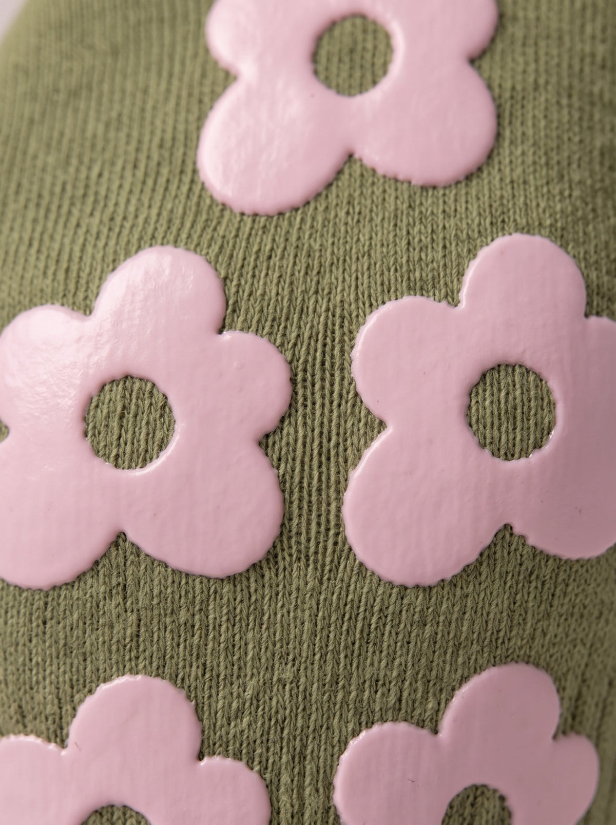 Close-up of olive green balanced. grip socks with pink silicone flower grips