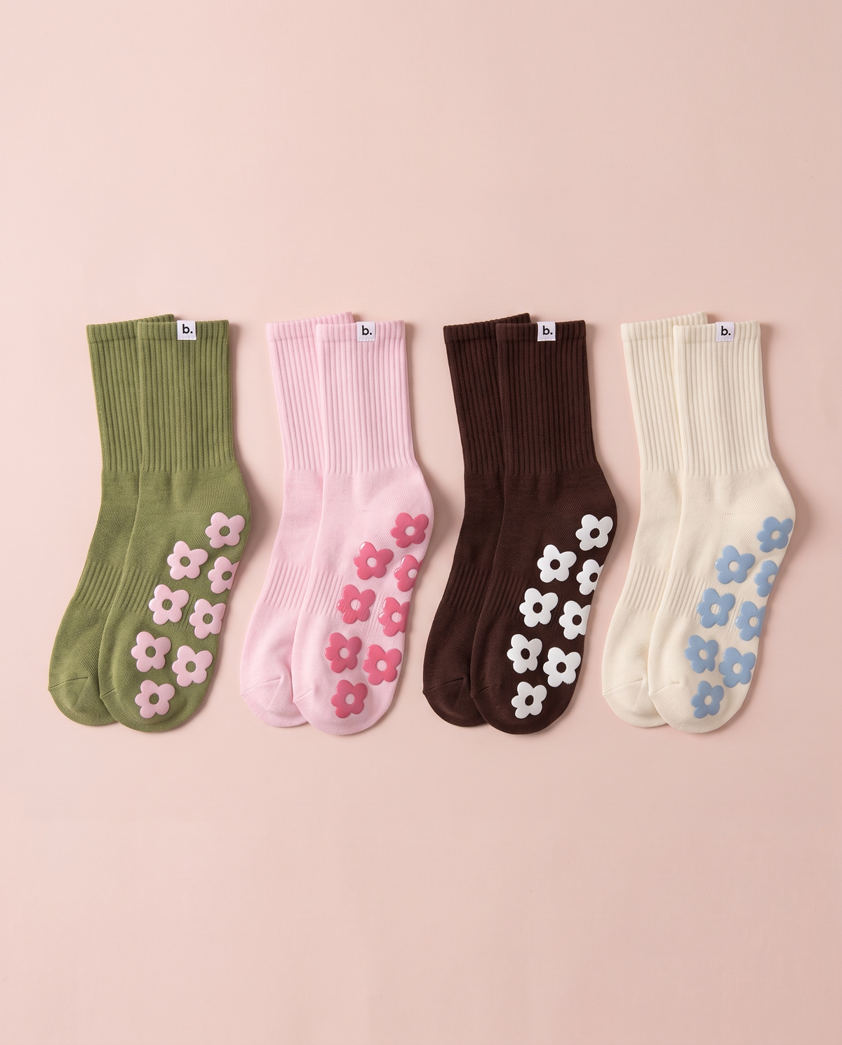 All four colours of balanced. grip socks laid flat on blush paper